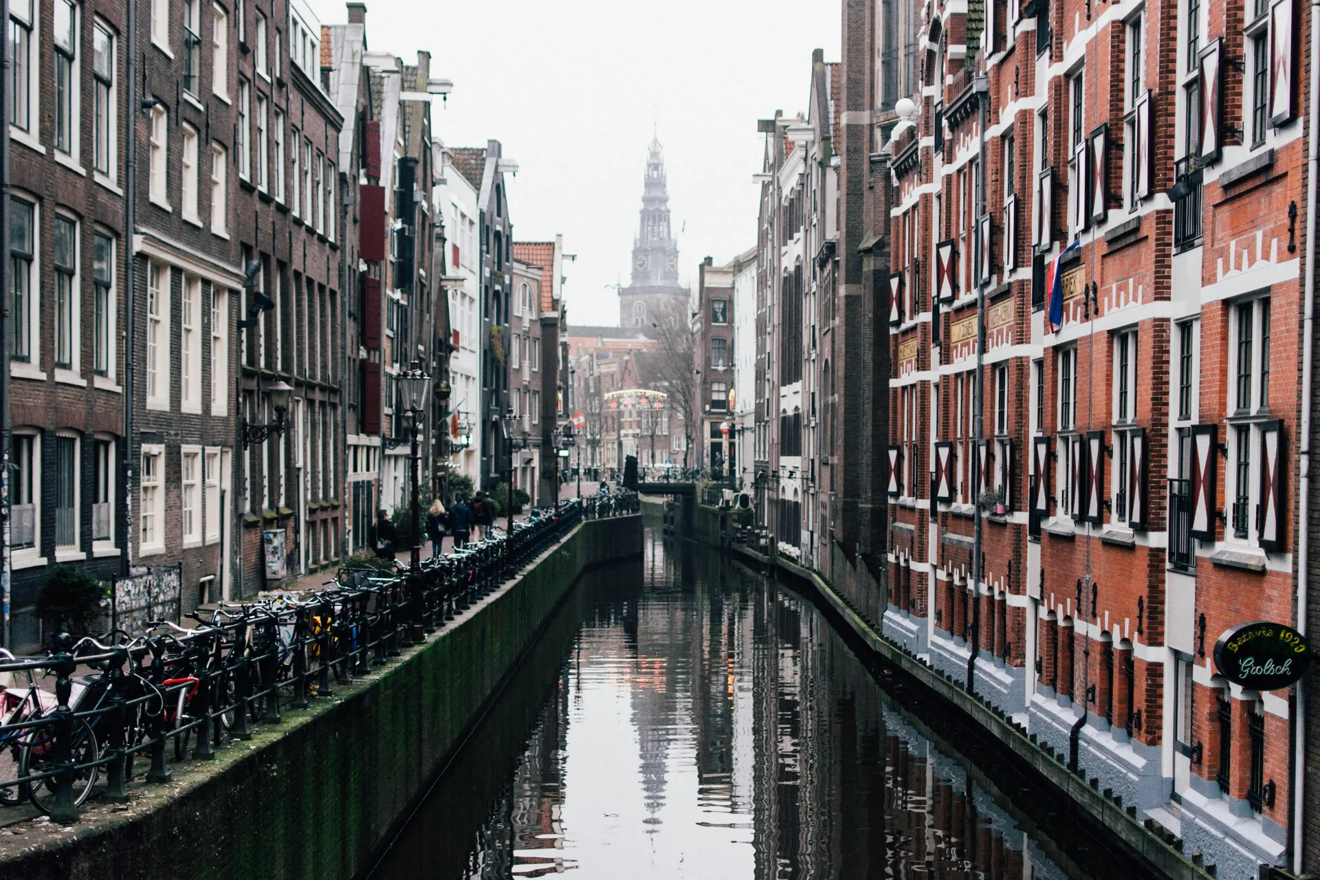 "Amsterdam's canal with historic buildings and bicycles along the banks, a destination in Europe to visit in 2025."