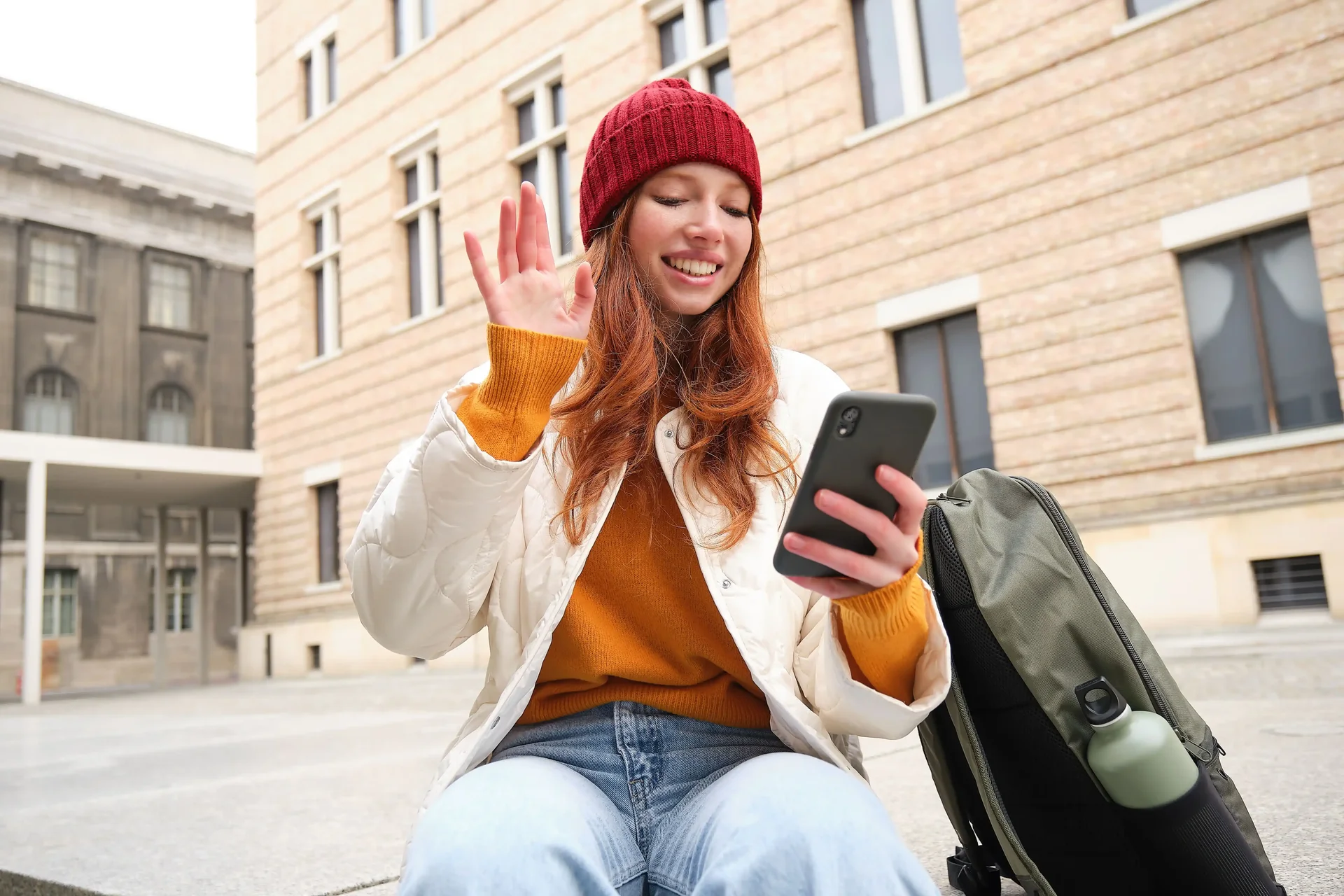 Jovem viajante em chamada no smartphone com conexão por eSIM durante viagem internacional