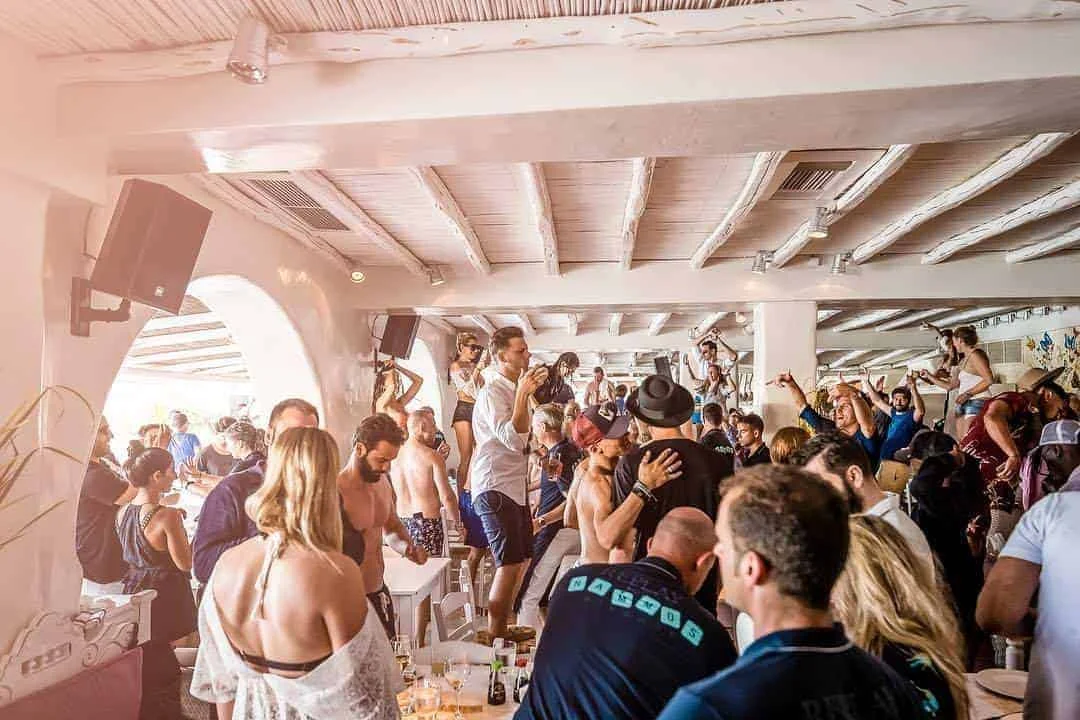 Festa diurna, pessoas em cima das mesas e cadeiras, dançando
