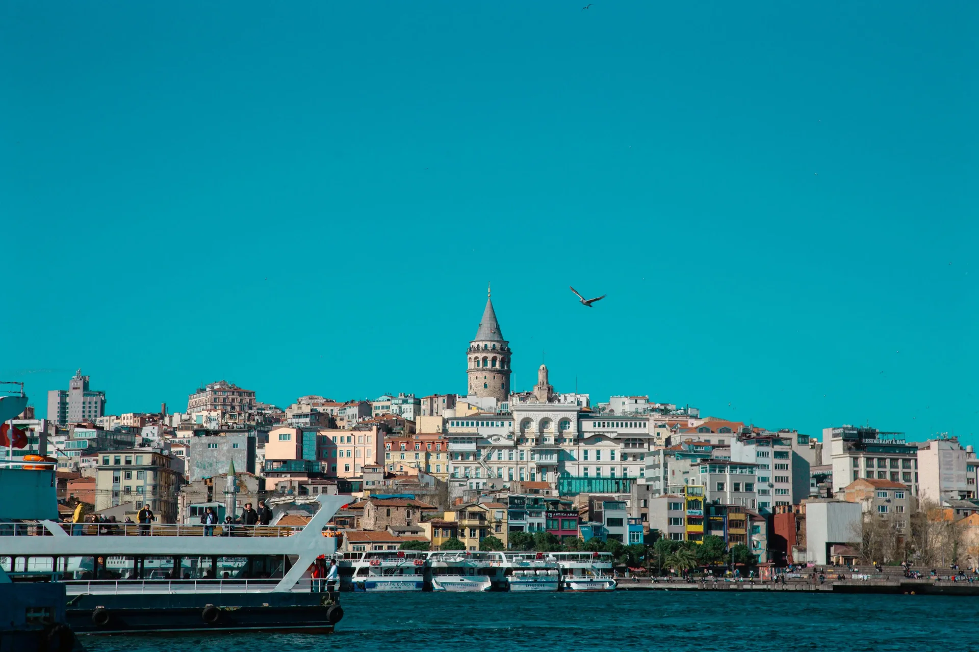Torre de Gálata em Istambul, vista de longe com arquitetura otomana e céu azul ao fundo.