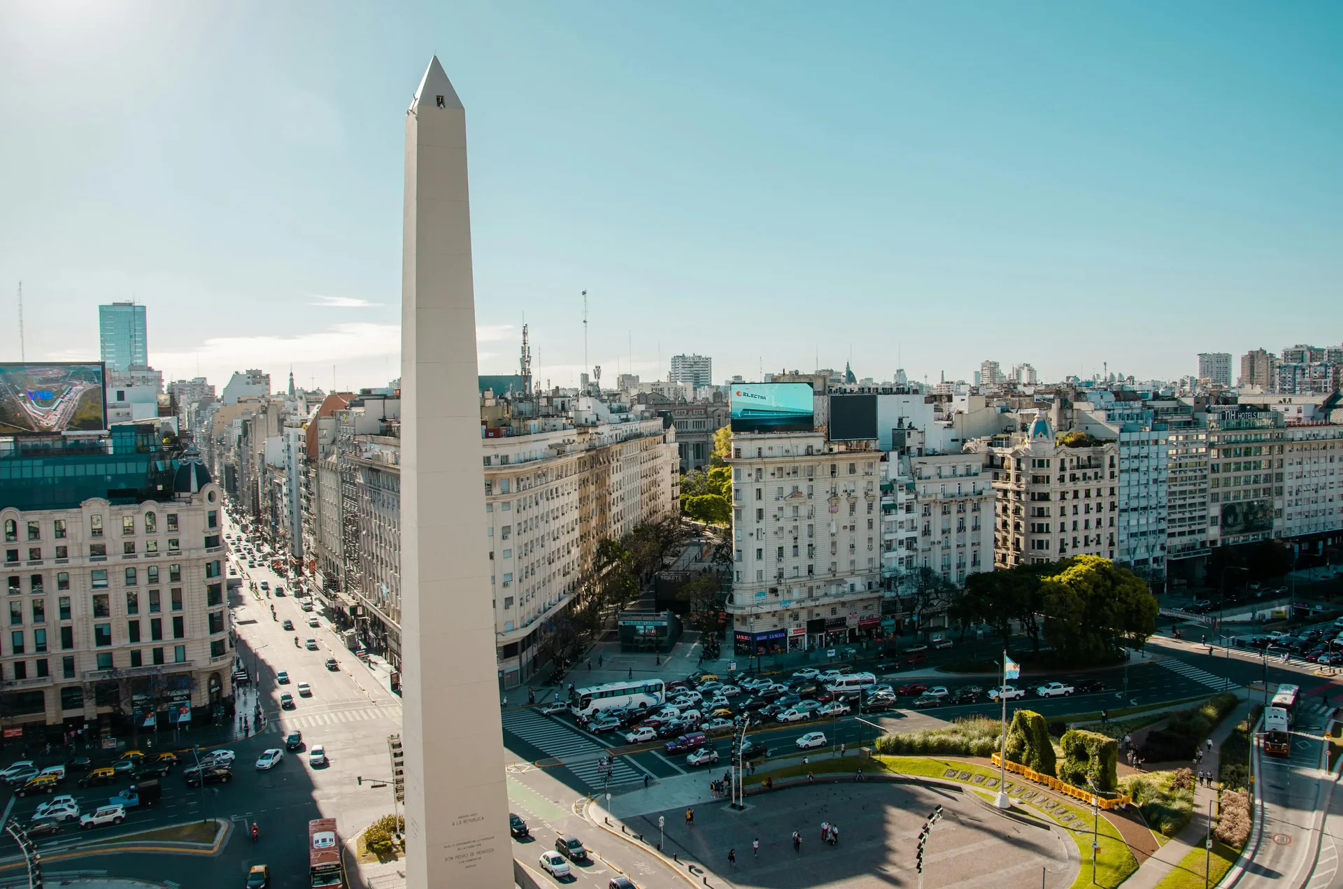 Obelisco de Buenos Aires com edifícios e trânsito ao fundo, localizado na famosa Avenida 9 de Julio.