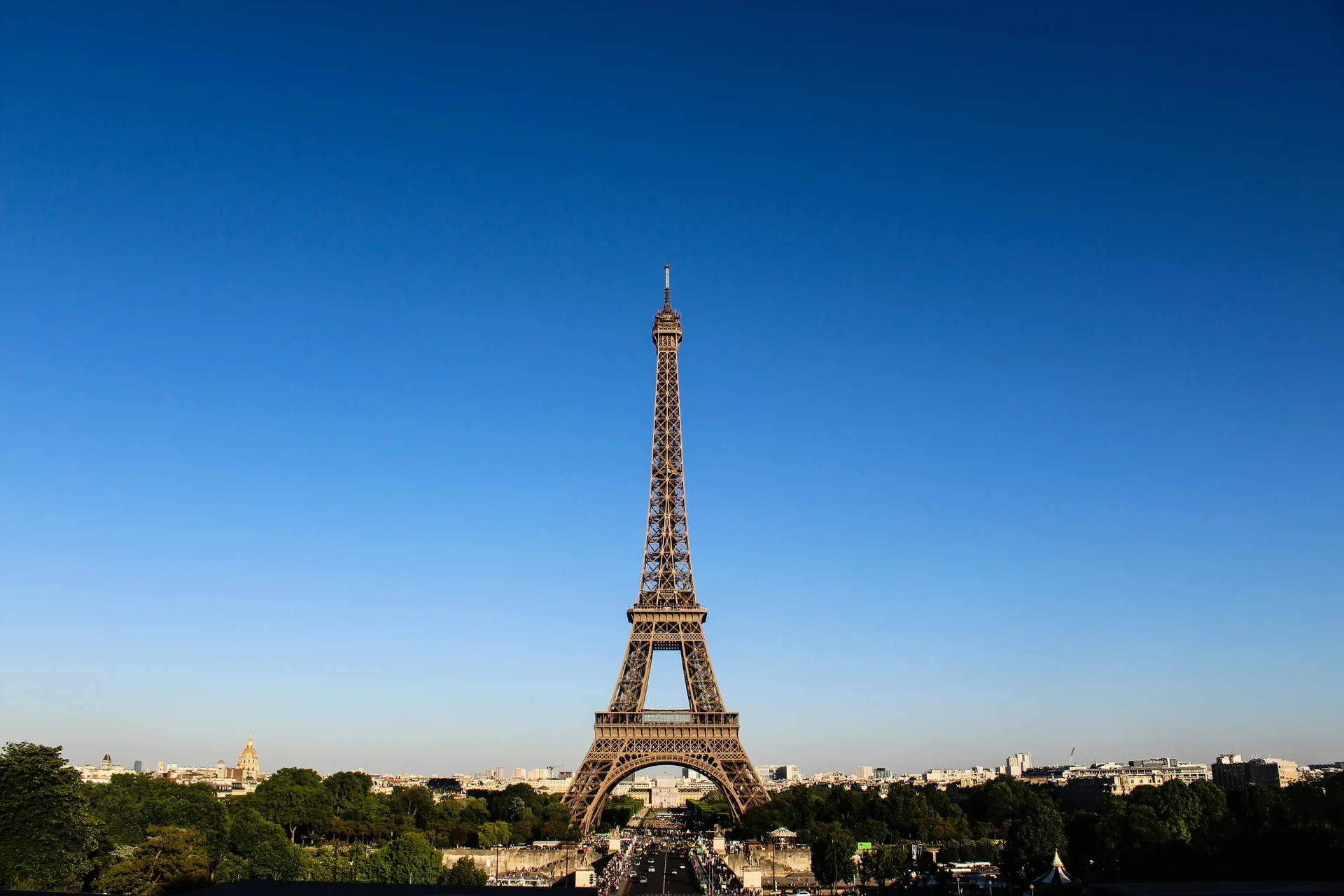 Torre Eiffel em Paris com céu azul claro ao fundo, vista icônica de um dos monumentos mais visitados da Europa.
