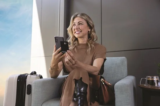 Mulher loira usando o celular em um aeroporto