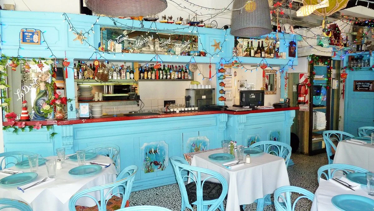 Ambiente do restaurante La Pescadorita, com decoração temática de pescaria e mesas dispostas em um espaço vibrante.